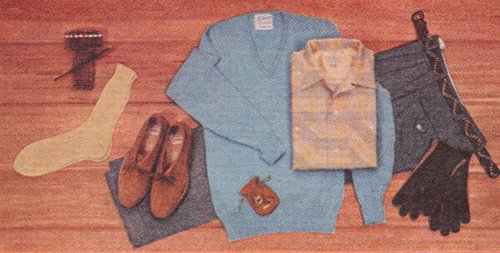 A picture of men's clothing and shoes arranged on a wooden floor.